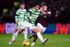 Celtic midfielder Reo Hatate, left, battles with Cammy Devlin of Hearts for the ball